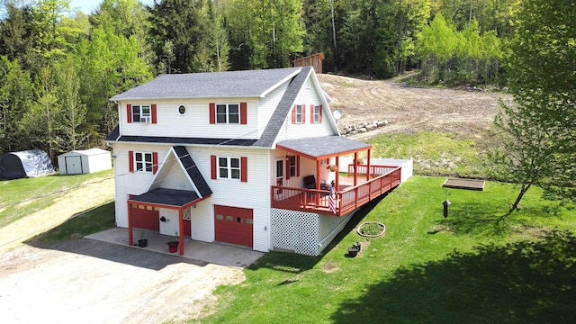 412 Covered Bridge Rd, Irasburg, VT 05845 - view of front of house featuring driveway, an attached garage, a front lawn, a storage unit, and a forest view