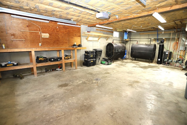 412 Covered Bridge Rd, Irasburg, VT 05845 - garage with oil tank, a workshop area, and a garage door opener
