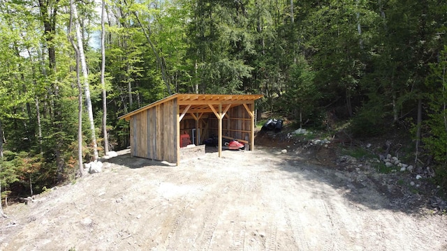 412 Covered Bridge Rd, Irasburg, VT 05845 - view of pole building with a carport, a forest view, and driveway
