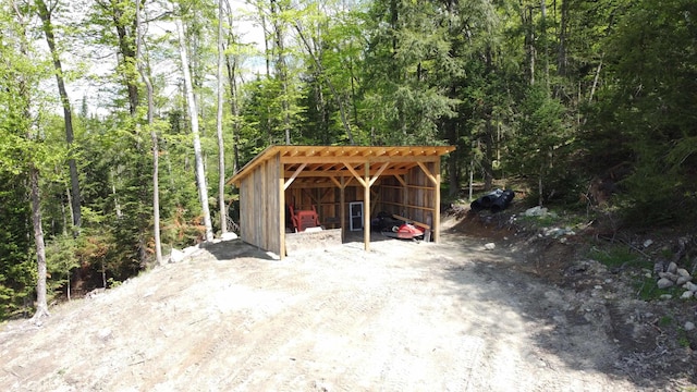 412 Covered Bridge Rd, Irasburg, VT 05845 - view of vehicle parking featuring a wooded view, a carport, and a pole building