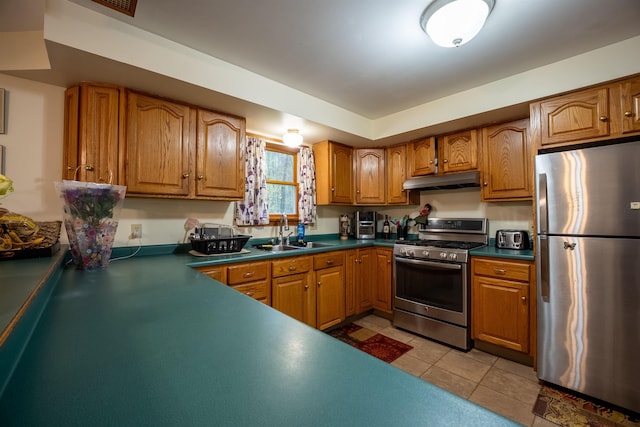 175 Blackwater Rd, Somersworth, NH 03878 - kitchen with stainless steel appliances, a sink, under cabinet range hood, brown cabinetry, and dark countertops