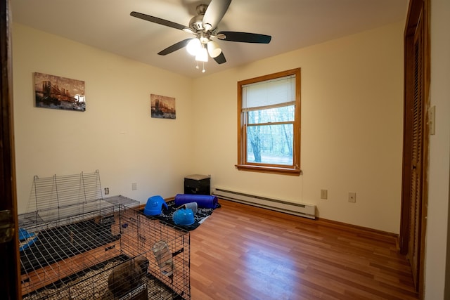 175 Blackwater Rd, Somersworth, NH 03878 - exercise area featuring a baseboard heating unit, wood finished floors, a ceiling fan, and baseboards