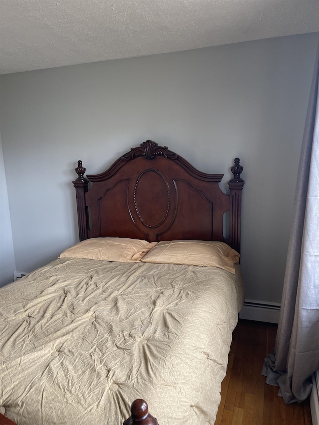 bedroom with hardwood / wood-style flooring and a baseboard radiator
