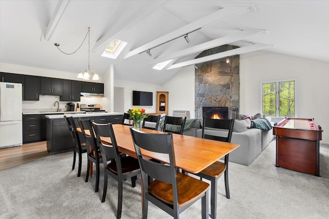6 Roundtree Rd, Winhall, VT 05340 - dining room featuring light carpet, a fireplace, a skylight, and a chandelier