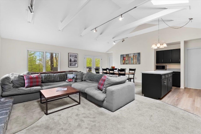 6 Roundtree Rd, Winhall, VT 05340 - living area with track lighting, lofted ceiling, a chandelier, and light carpet