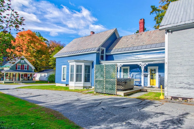 56 Andover St, Ludlow, VT 05149 - back of house with a chimney, metal roof, a standing seam roof, and a high end roof
