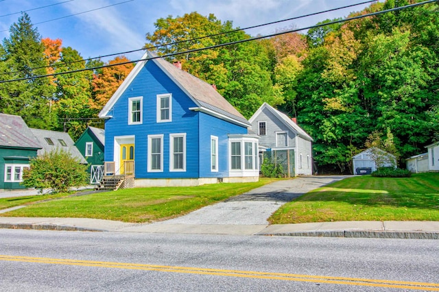 56 Andover St, Ludlow, VT 05149 - view of front of property featuring driveway, a front yard, and a chimney