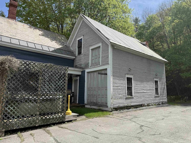 56 Andover St, Ludlow, VT 05149 - view of side of home with metal roof and a chimney