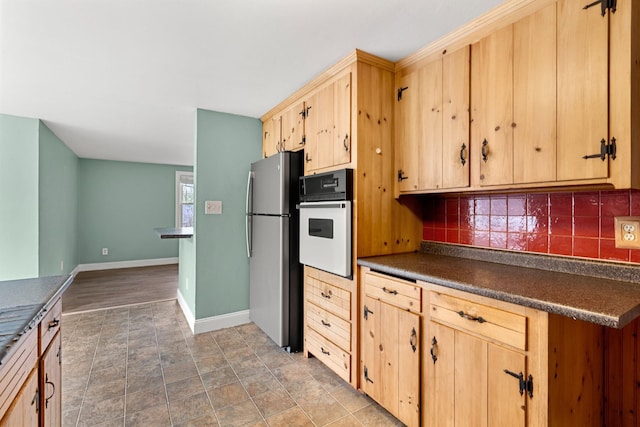 7 Pond Rd, Derry, NH 03038 - kitchen with freestanding refrigerator, white oven, light brown cabinets, and dark countertops