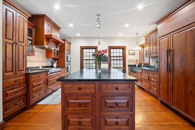 kitchen featuring dark countertops, a sink, stainless steel appliances, decorative backsplash, and recessed lighting