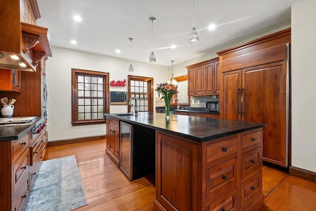 kitchen with dark countertops, a sink, baseboards, and recessed lighting