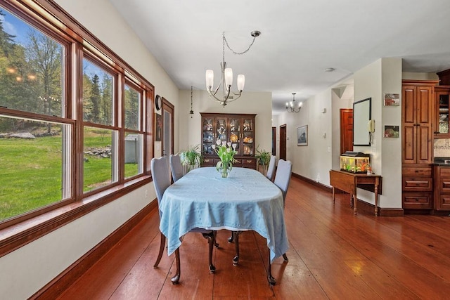 dining space featuring a chandelier, hardwood / wood-style floors, and baseboards
