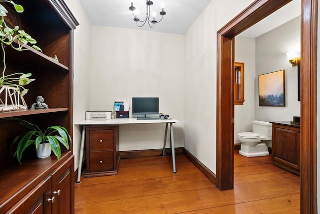home office featuring light wood-type flooring, a chandelier, and baseboards