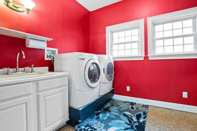 washroom with washer and clothes dryer, baseboards, and cabinet space