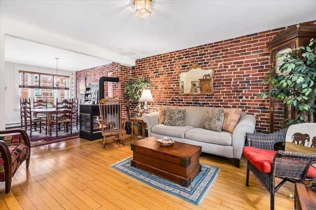 67 Kidder St, Manchester, NH 03101 - living room with brick wall, a wood stove, wood-type flooring, and beam ceiling