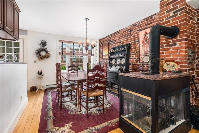 67 Kidder St, Manchester, NH 03101 - dining space with light wood-style floors, baseboards, a chandelier, a baseboard radiator, and brick wall