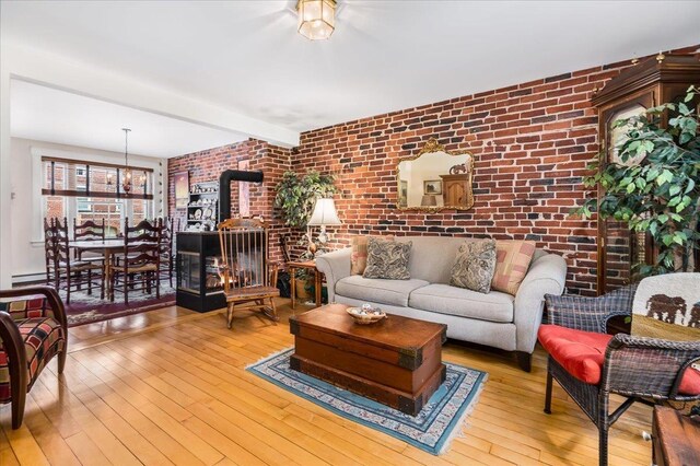 67 Kidder St, Manchester, NH 03101 - living room featuring brick wall, wood-type flooring, a wood stove, and beamed ceiling