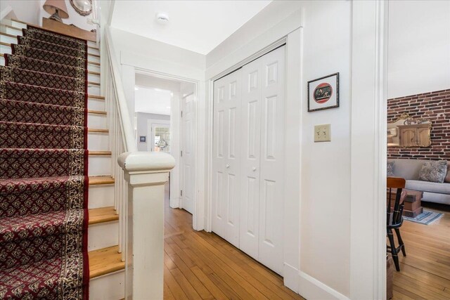 67 Kidder St, Manchester, NH 03101 - stairway with wood-type flooring, baseboards, and brick wall