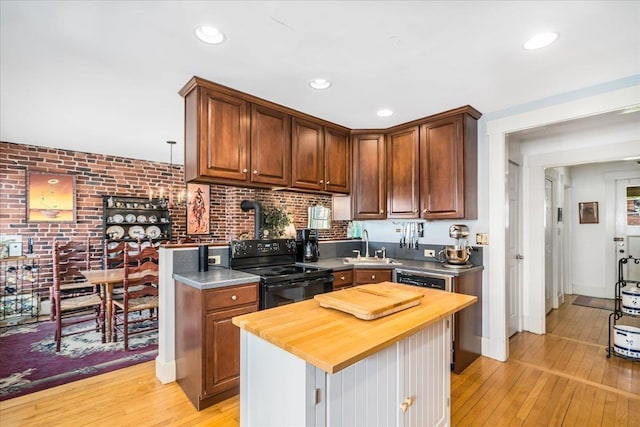 67 Kidder St, Manchester, NH 03101 - kitchen featuring electric range, wooden counters, light wood-style floors, brick wall, and recessed lighting