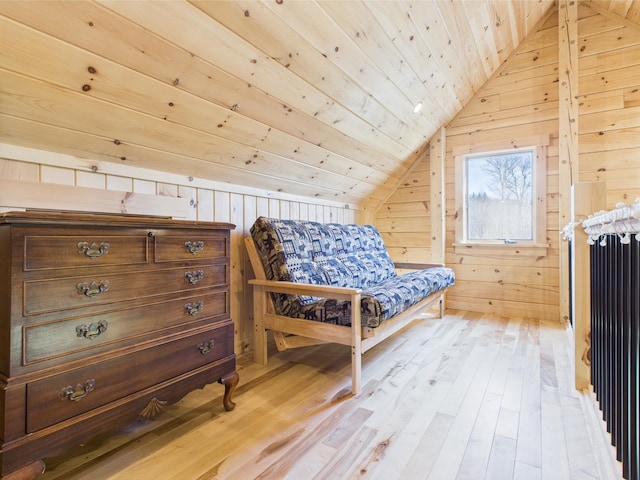 bedroom with vaulted ceiling, wooden walls, wood ceiling, light wood finished floors, and radiator heating unit