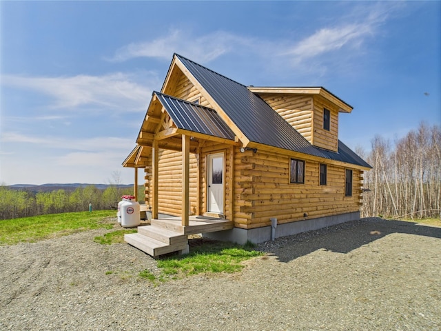 view of home's exterior featuring log exterior and metal roof