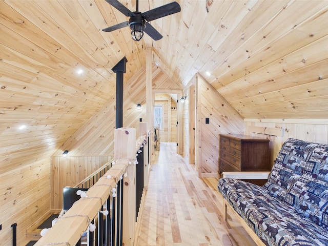 living area featuring wooden ceiling, wood walls, an upstairs landing, lofted ceiling, and light wood-style floors