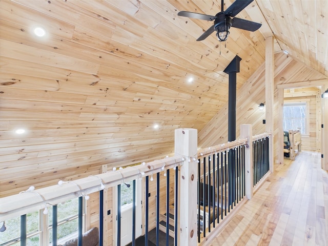 hall featuring wooden ceiling, lofted ceiling, plenty of natural light, wood walls, and recessed lighting