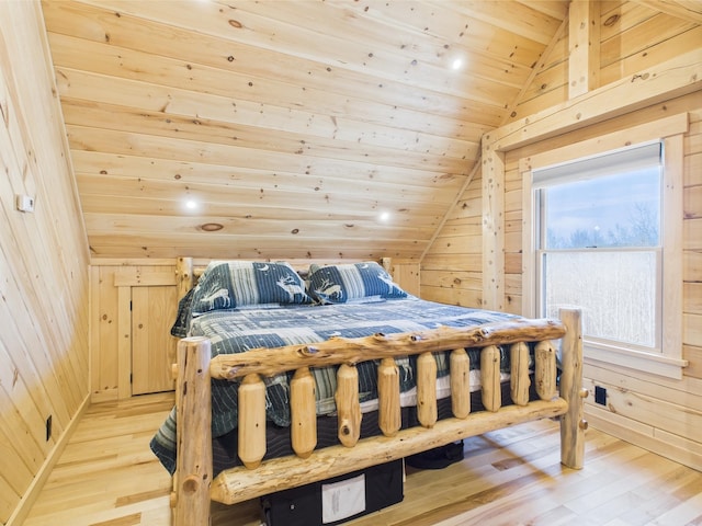 bedroom with lofted ceiling, wooden walls, light wood finished floors, and wooden ceiling