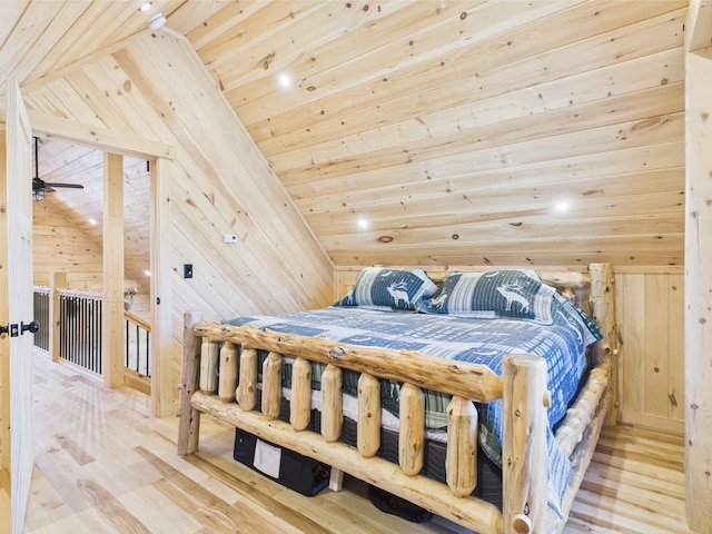 bedroom with wooden ceiling, vaulted ceiling, wooden walls, and wood finished floors