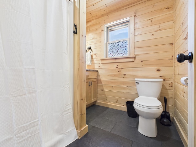 bathroom with wooden walls, toilet, vanity, tile patterned flooring, and curtained shower