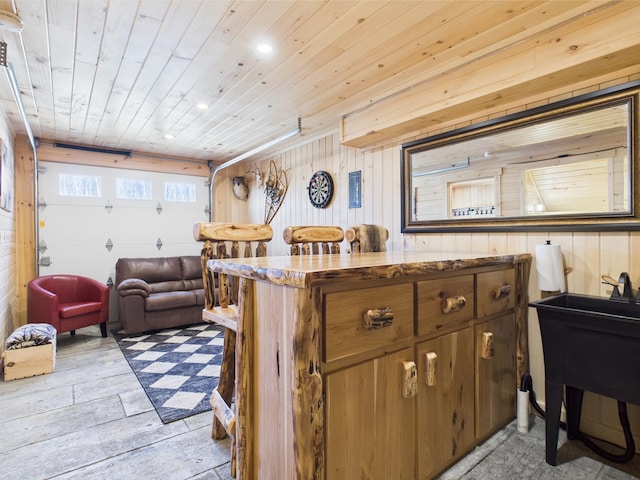 living area with wood ceiling, wood walls, light wood-style flooring, and recessed lighting