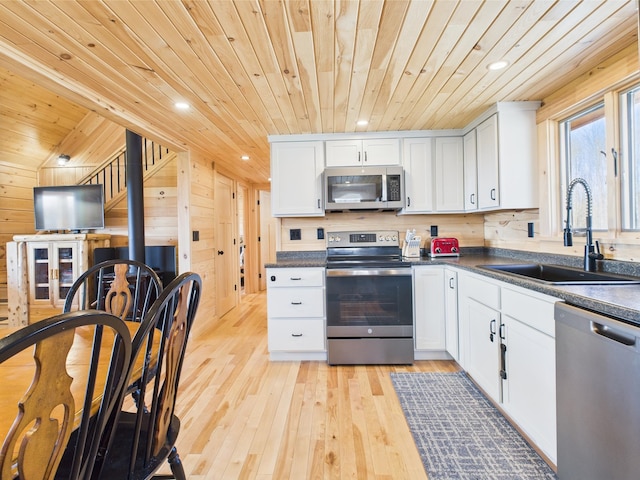 kitchen with appliances with stainless steel finishes, a sink, wood ceiling, dark countertops, and recessed lighting