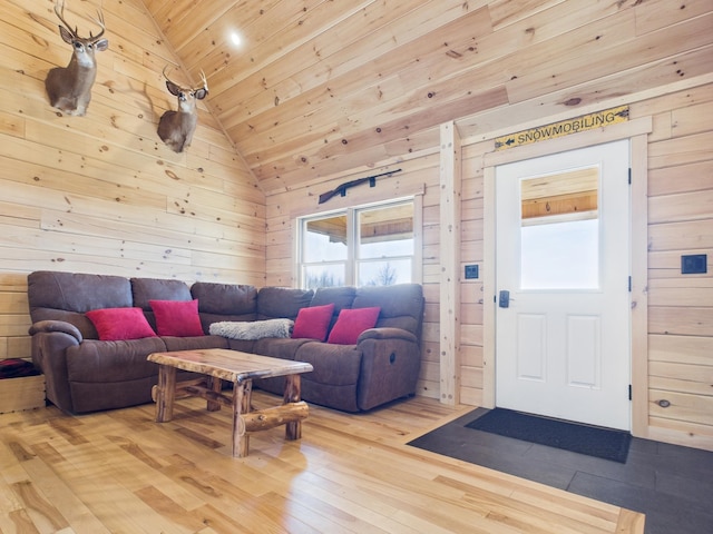 living area with lofted ceiling, wood ceiling, hardwood / wood-style floors, and wooden walls