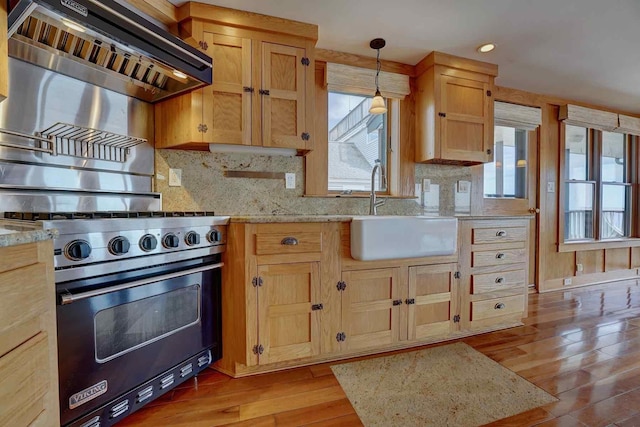 5 Great Boars Head Ave, Hampton, NH 03842 - kitchen featuring premium stove, a sink, wall chimney range hood, light wood-type flooring, and decorative backsplash