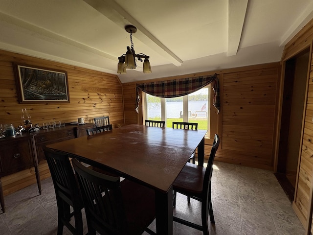 dining area with wooden walls and a chandelier