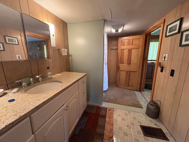 bathroom featuring wooden walls and vanity