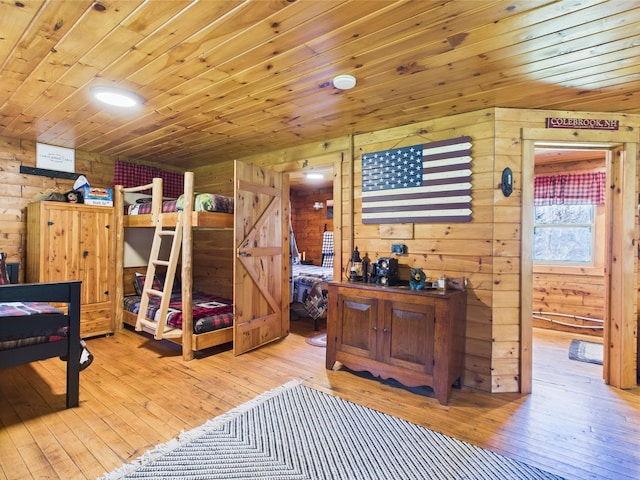bedroom featuring wood ceiling, light wood finished floors, and wood walls