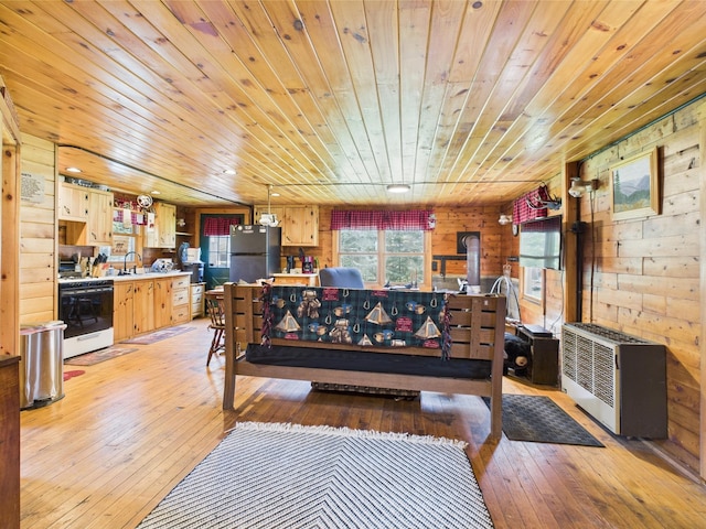 living area featuring wooden ceiling, light wood finished floors, wood walls, and heating unit