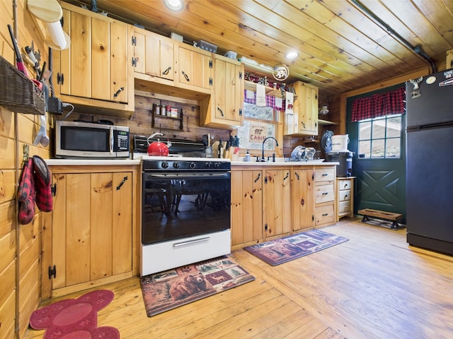 kitchen with freestanding refrigerator, stainless steel microwave, gas stove, wooden ceiling, and a sink