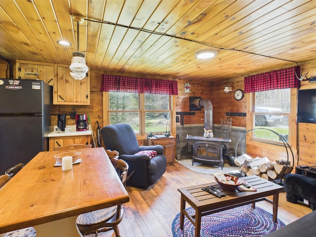 living room with a wood stove, wood ceiling, light wood finished floors, wood walls, and recessed lighting