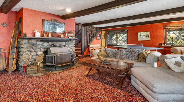 148 Lucerne Ave Unit 15, Laconia, NH 03246 - living room featuring beamed ceiling, a textured ceiling, stairs, carpet floors, and a wood stove