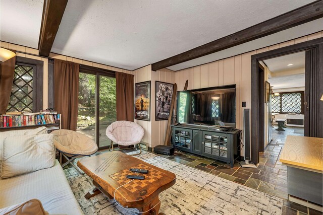 148 Lucerne Ave Unit 15, Laconia, NH 03246 - living room with beam ceiling, stone tile flooring, a textured ceiling, and wood walls