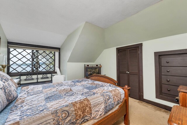 148 Lucerne Ave Unit 15, Laconia, NH 03246 - bedroom featuring light carpet, a closet, baseboards, and lofted ceiling
