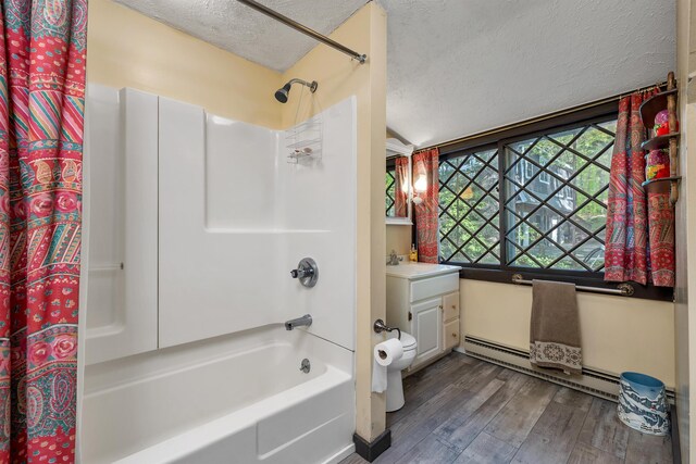 148 Lucerne Ave Unit 15, Laconia, NH 03246 - bathroom featuring a textured ceiling, a baseboard radiator, shower / bath combo, wood finished floors, and vanity