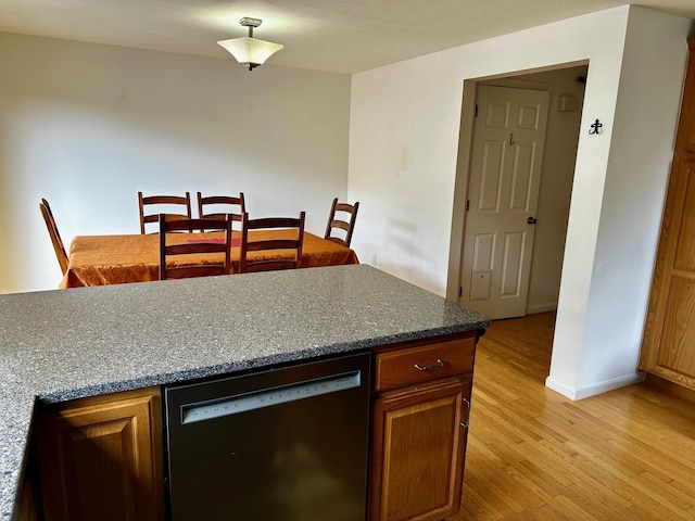 kitchen with dishwasher, light wood-style floors, baseboards, dark countertops, and brown cabinetry