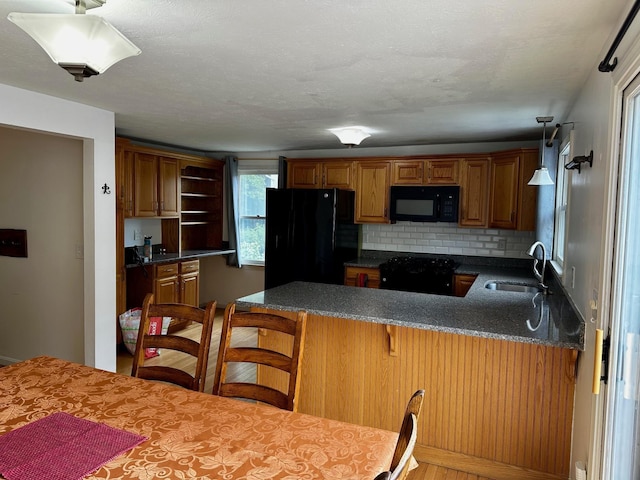 kitchen featuring black appliances, a sink, a peninsula, tasteful backsplash, and open shelves