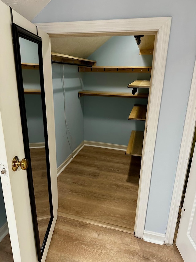 spacious closet featuring wood finished floors and lofted ceiling