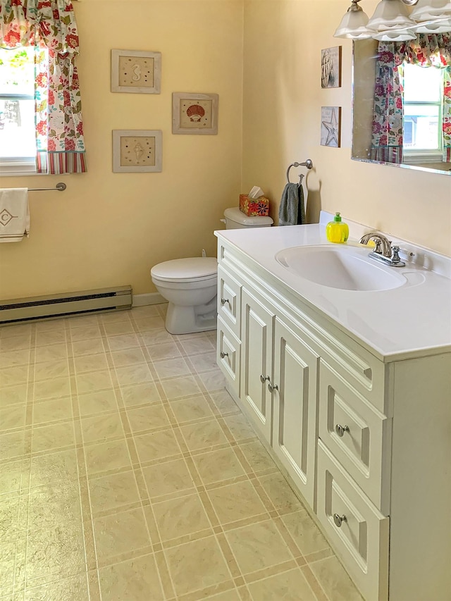 121 Platt Rd, Highgate, VT 05459 - half bathroom with a baseboard radiator, vanity, and toilet