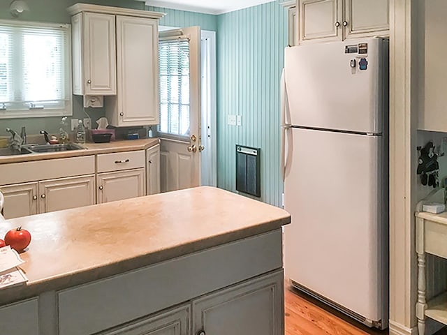 121 Platt Rd, Highgate, VT 05459 - kitchen featuring freestanding refrigerator, light wood-type flooring, a sink, light countertops, and white cabinetry