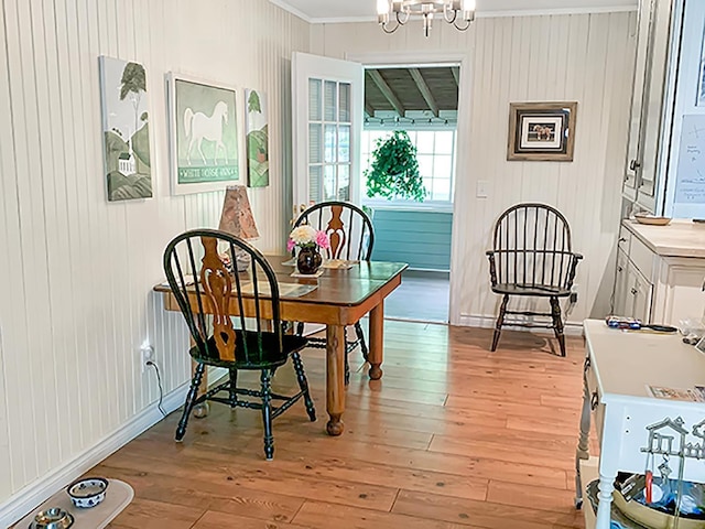 121 Platt Rd, Highgate, VT 05459 - dining area featuring crown molding, light wood-style floors, a chandelier, and wood walls
